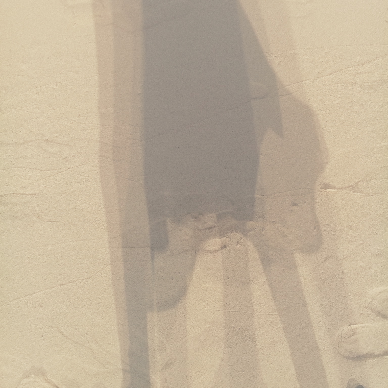 A multi-exposed photograph of a person's shadows over beach sand.